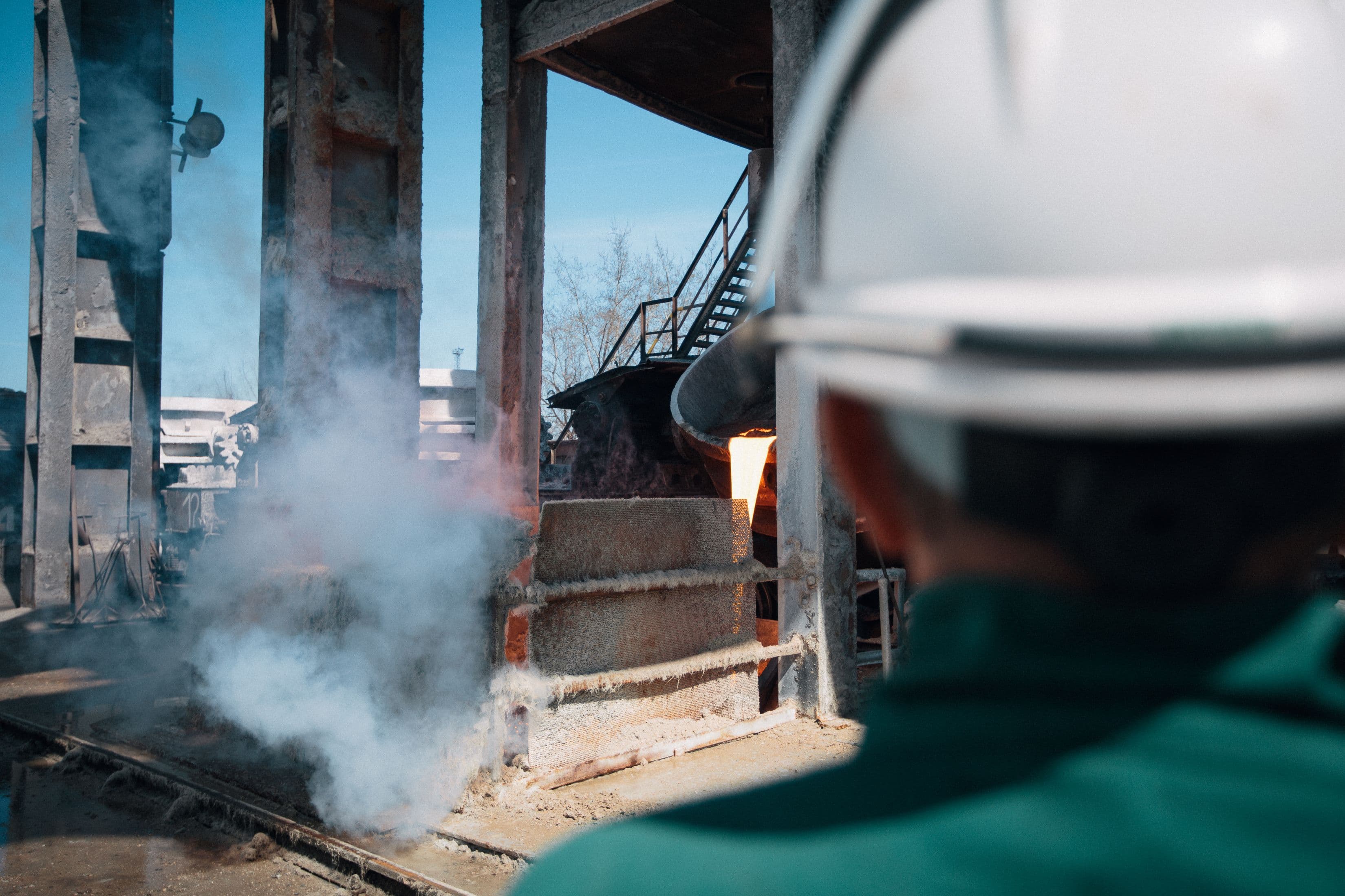 Industrial facility with worker helmet and high-temperature process